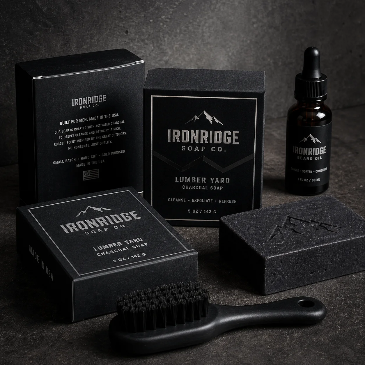Black grooming products from Ironridge Soap Co featuring charcoal soap bars, beard oil bottle, and brush on dark textured surface