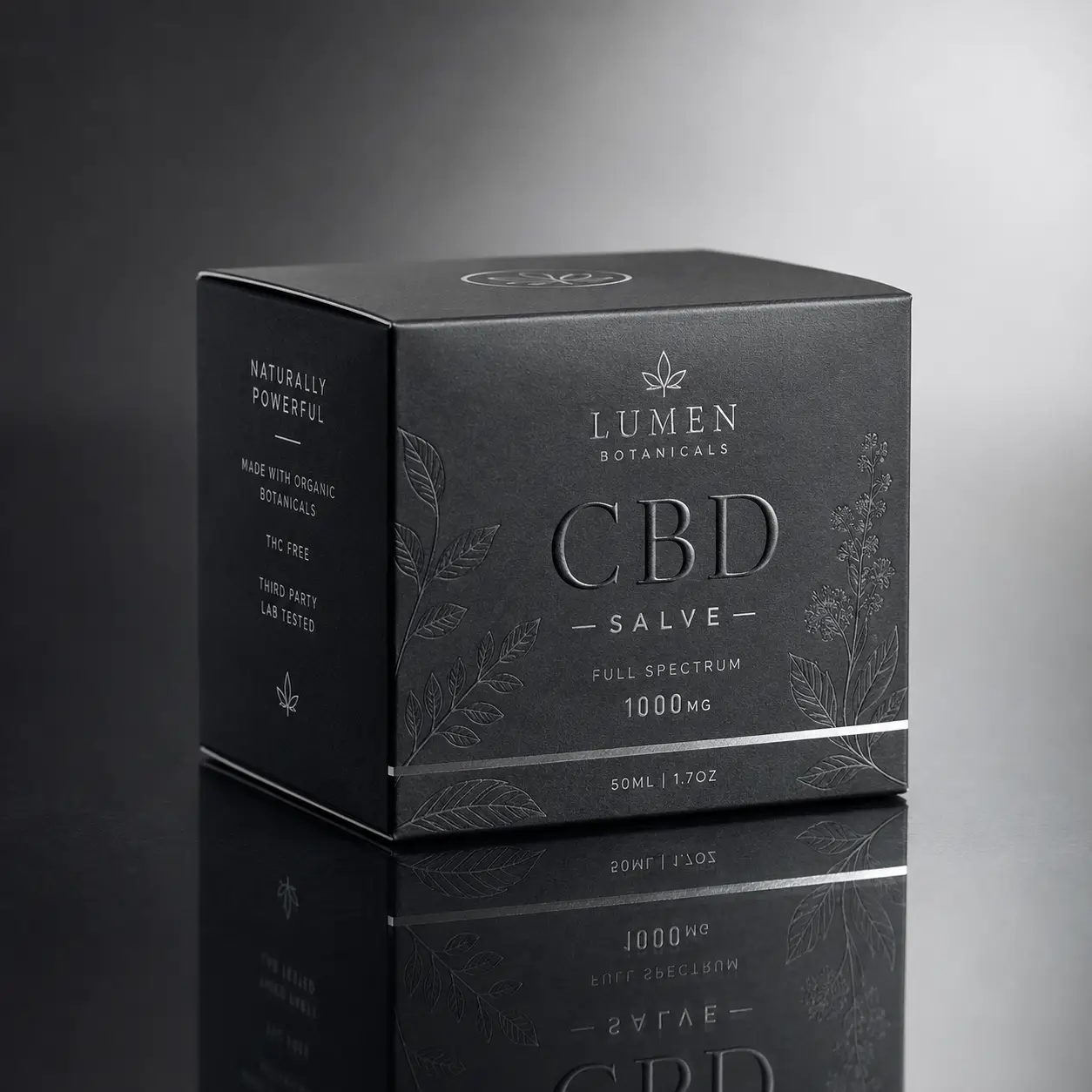 Dark luxury CBD salve box packaging by Lumen Botanicals, 1000mg full spectrum, matte black with silver botanical embossing