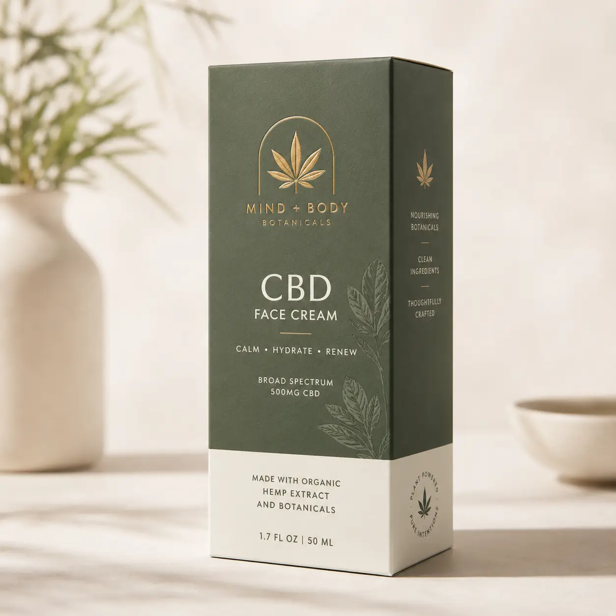 Dark green CBD face cream box by Mind + Body Botanicals, gold hemp leaf logo, 500mg broad spectrum, elegant minimal packaging design