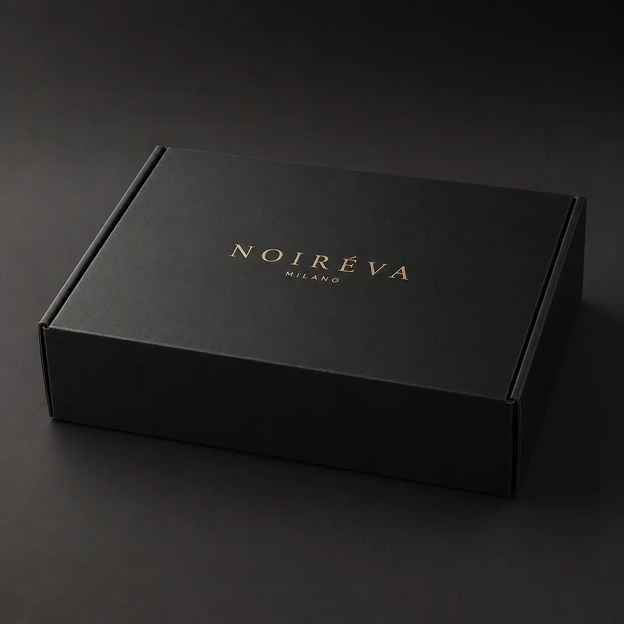 Luxury black mailer box with gold foil NOIRÉVA MILANO logo, elegant premium packaging design on dark background