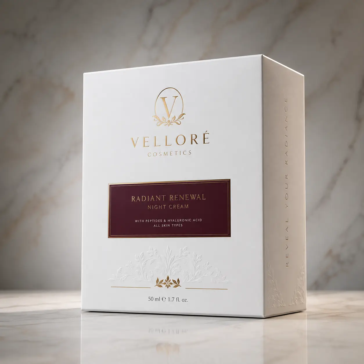 Luxury white cosmetic box packaging for Velloré Radiant Renewal Night Cream with gold foil logo on marble surface