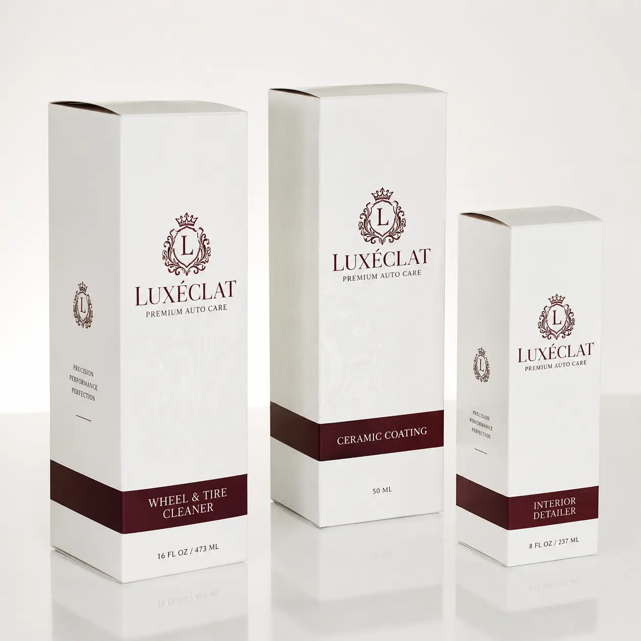 Three white luxury auto care product boxes by Luxéclat with dark red branding: Wheel Cleaner, Ceramic Coating, Interior Detailer