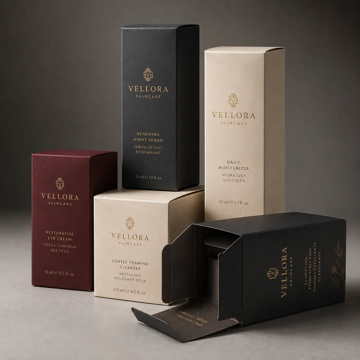 Luxury Vellora Skincare packaging collection in black, cream, and burgundy boxes with gold foil branding on gray background