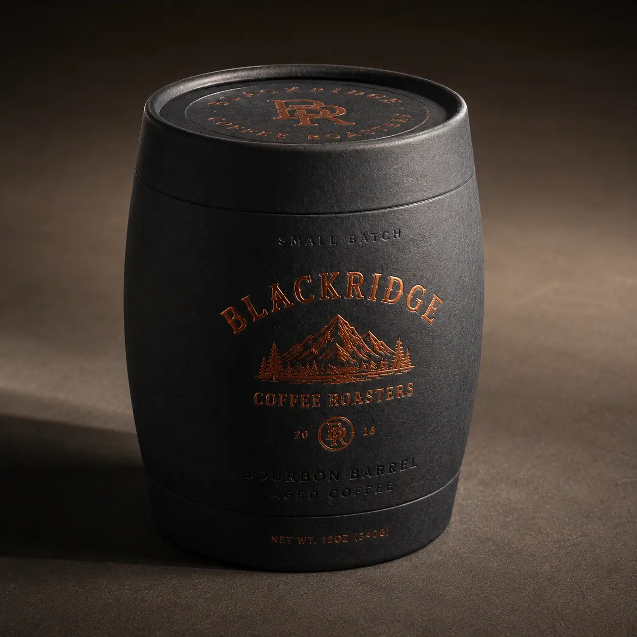 Blackridge Coffee Roasters bourbon barrel aged coffee packaging, matte black barrel-shaped container with copper foil branding, moody dark studio l...