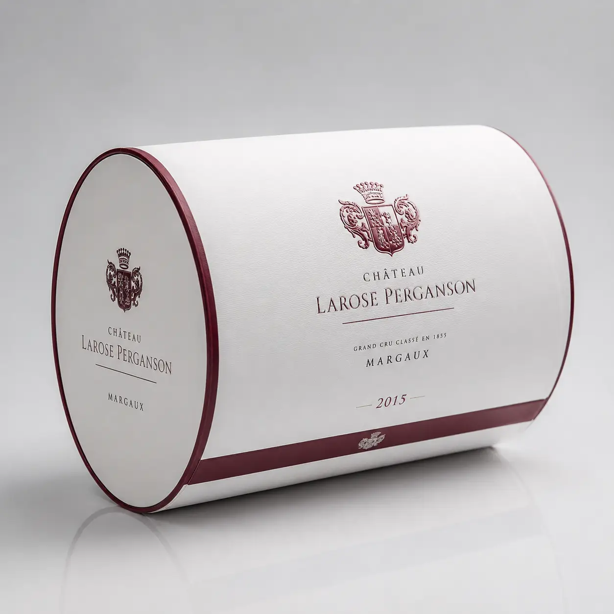 White cylindrical luxury wine box for Château Larose Perganson Margaux 2015, burgundy accents, embossed crest, premium packaging design