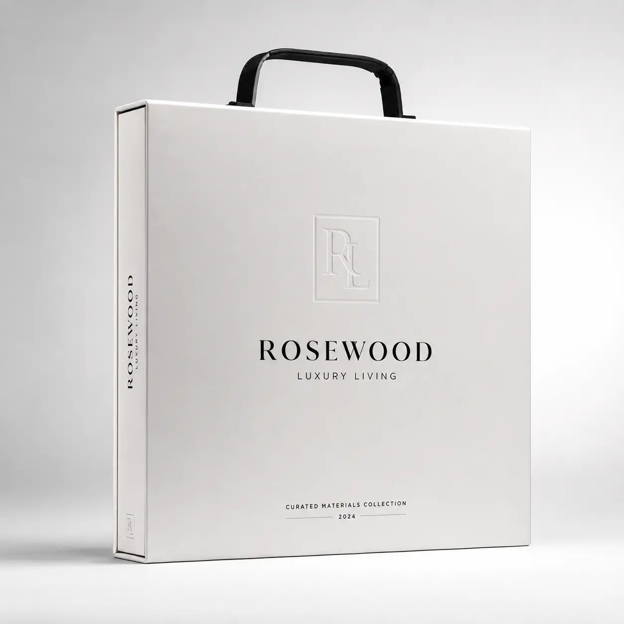 White luxury packaging box with black handle, embossed RL monogram, Rosewood Luxury Living branding, 2024 Curated Materials Collection