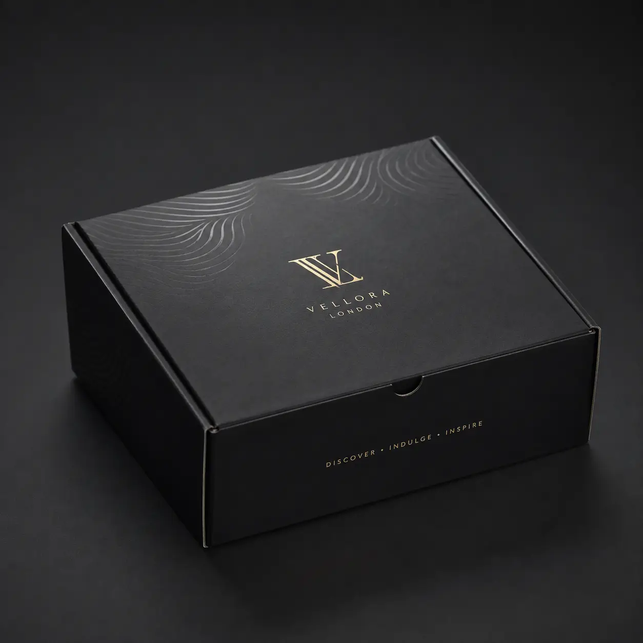 Luxury black mailer box with gold foil Vellora London logo and wave embossing, custom premium packaging by The Packaging Masters