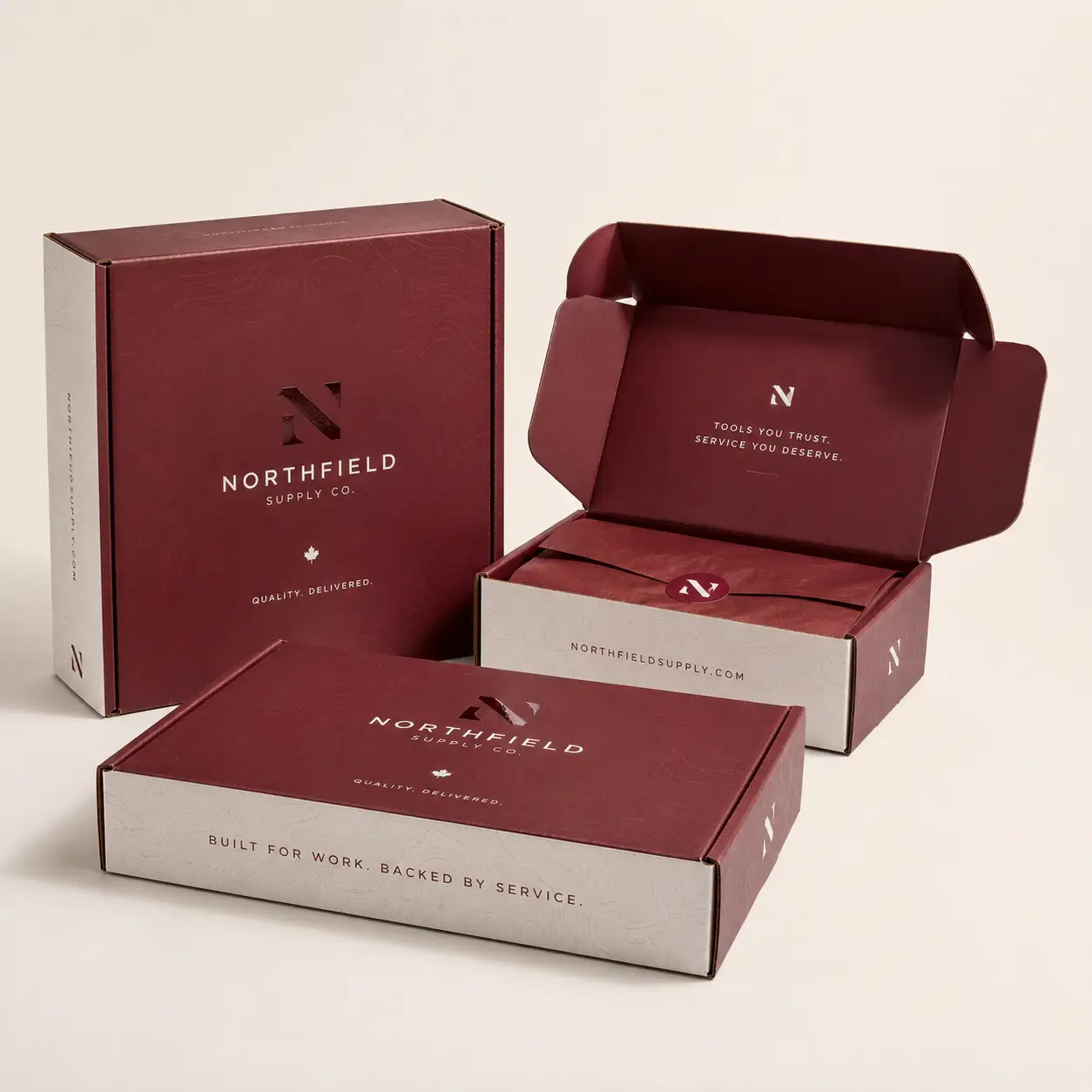 Custom branded mailer boxes in deep burgundy and cream for Northfield Supply Co., showcasing premium retail packaging design