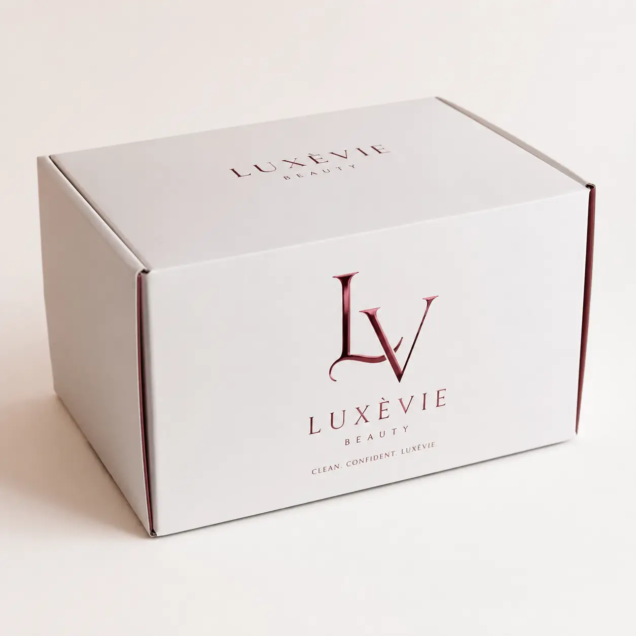Luxèvie Beauty white mailer box with rose gold LV logo and tagline Clean Confident Luxèvie luxury cosmetic packaging