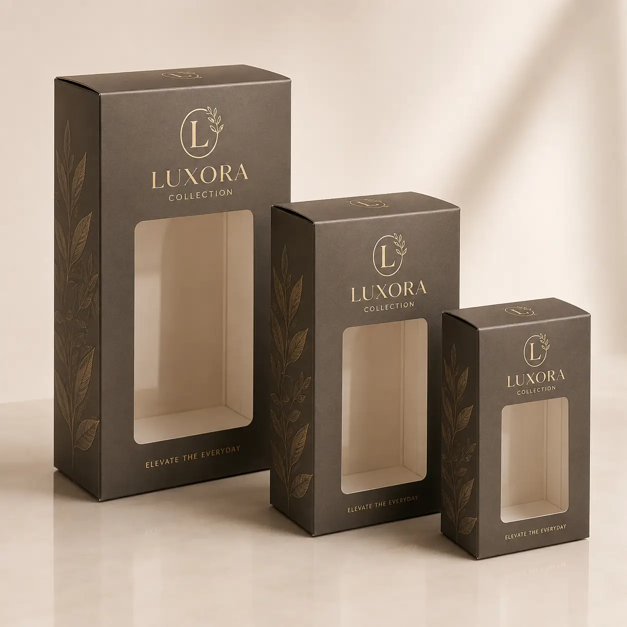Three dark brown Luxora Collection luxury window boxes in graduating sizes with gold foil botanical print packaging design