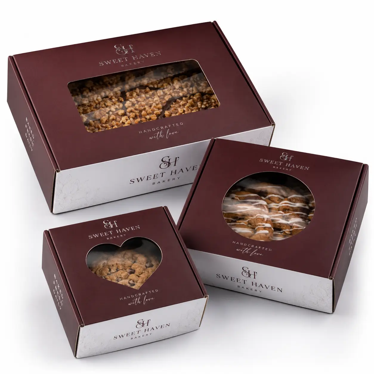 Three Sweet Haven Bakery custom bakery boxes in burgundy and silver with clear windows displaying cookies and pastries