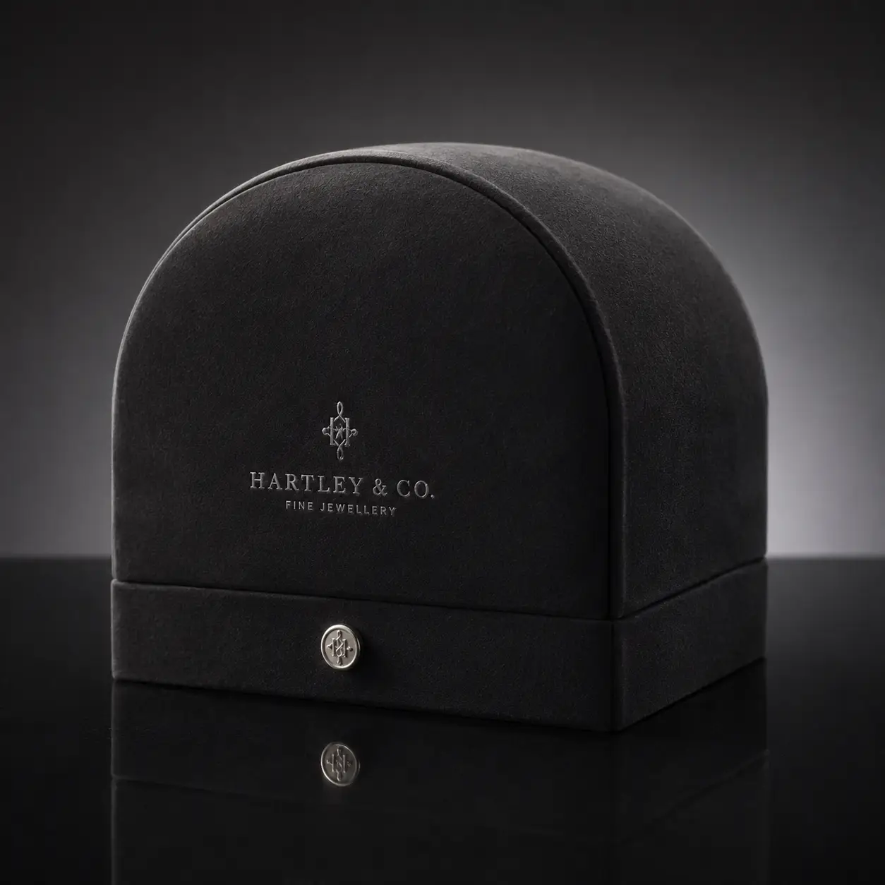 Luxury black velvet dome jewelry box by Hartley & Co. Fine Jewellery with silver logo clasp on dark reflective surface