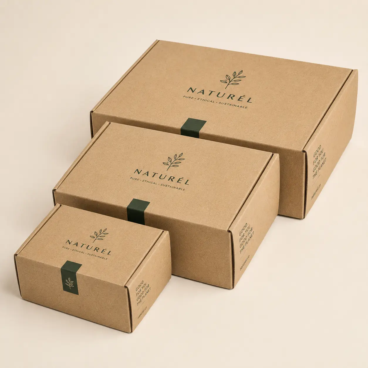 Three kraft brown Naturél eco-friendly mailer boxes in graduating sizes, printed with green botanical logo and sustainable branding