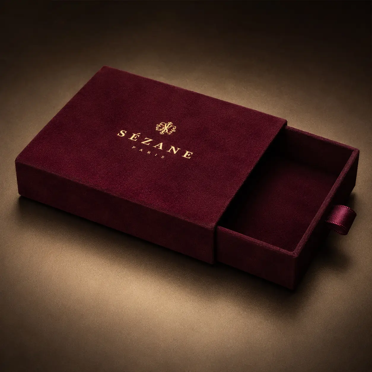 Sézane Paris luxury burgundy velvet sliding jewelry gift box with gold foil logo, elegant premium packaging design