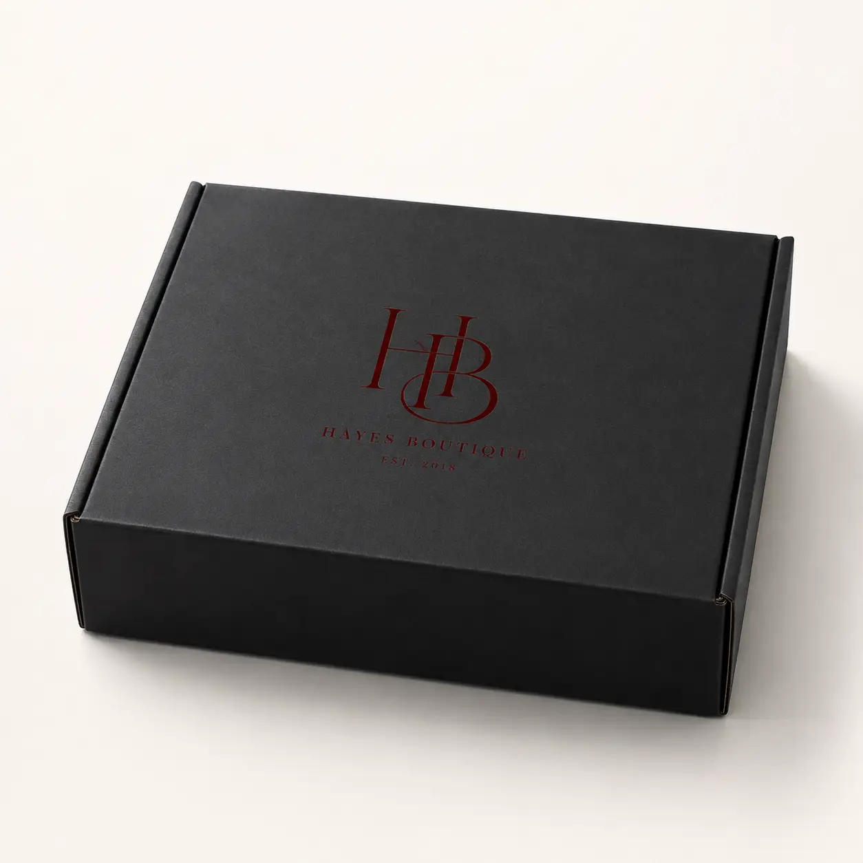 Black custom mailer box with dark red HB monogram logo for Hayes Boutique Est. 2018, luxury branded packaging design