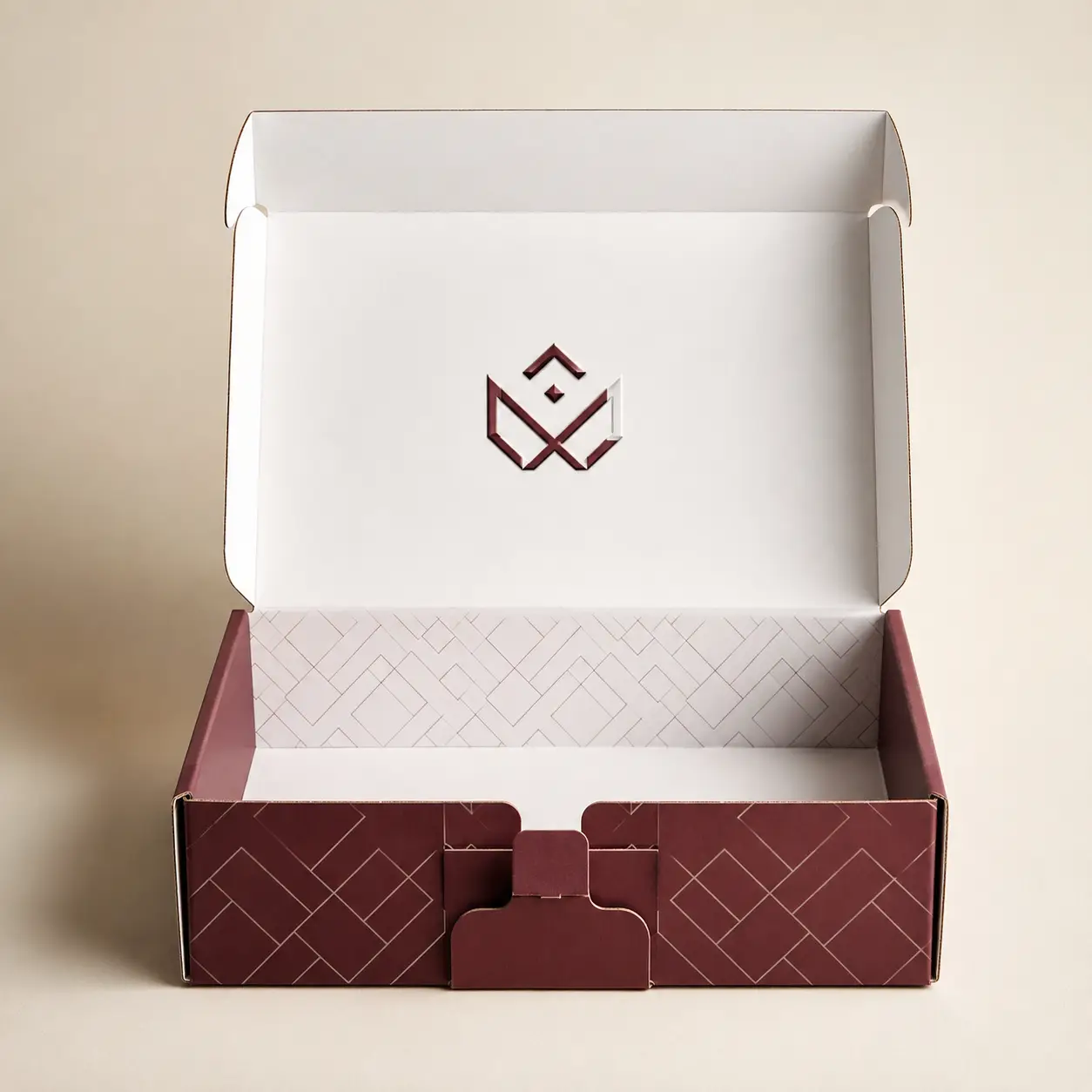 Open burgundy custom mailer box with geometric pattern, white interior, embossed logo, premium packaging design by The Packaging Masters