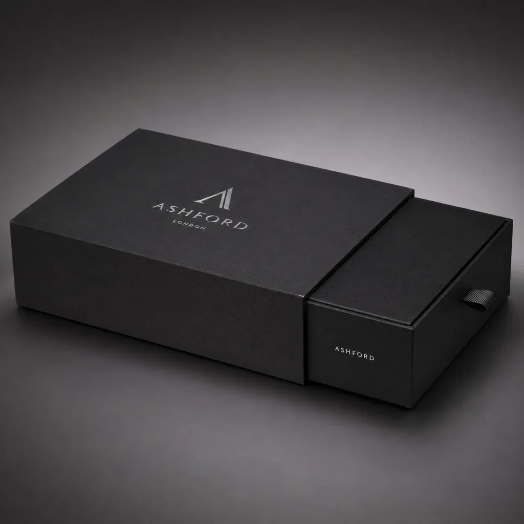 Luxury black sliding drawer gift box with silver Ashford London logo, premium rigid packaging design with ribbon pull tab
