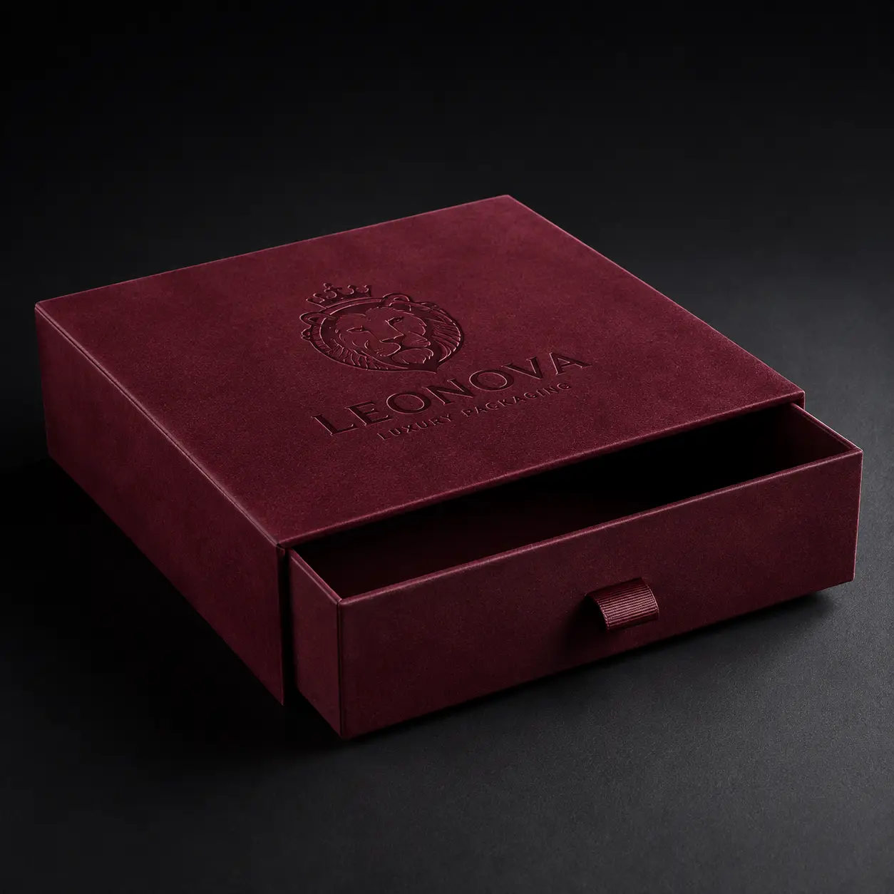 Burgundy velvet luxury drawer gift box with embossed lion logo, Leonova premium packaging, dark moody background