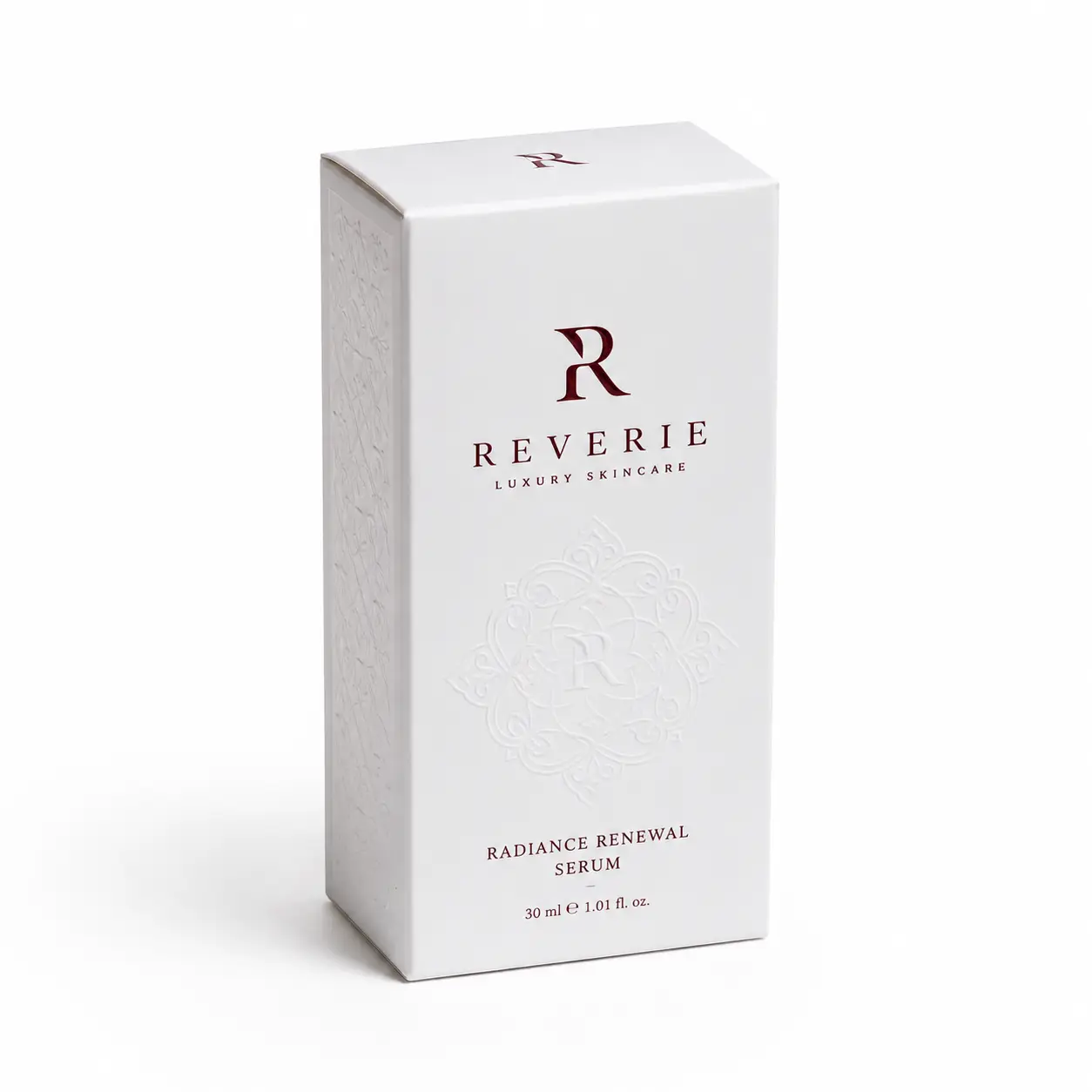 White luxury skincare box packaging for Reverie Radiance Renewal Serum 30ml with embossed floral design and burgundy logo