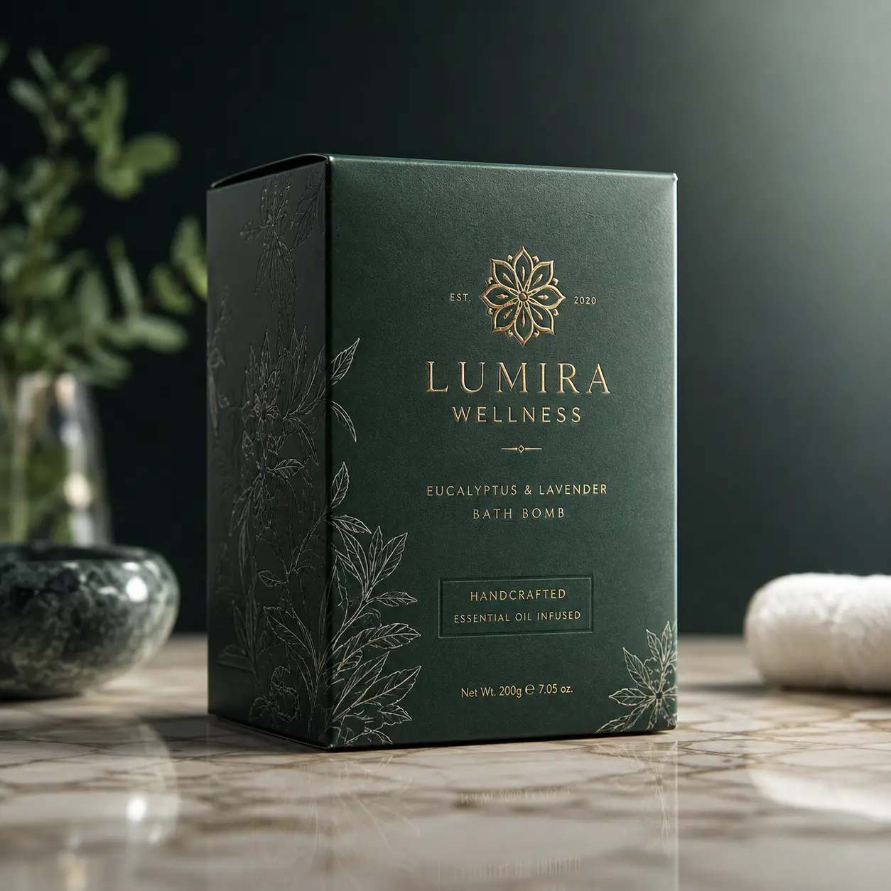 Lumira Wellness luxury green bath bomb box with gold foil eucalyptus lavender branding on marble surface, premium packaging design