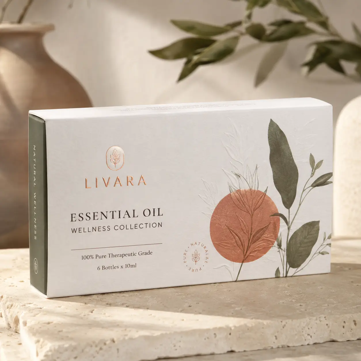 Livara Essential Oil Wellness Collection white luxury gift box with botanical design on stone surface, natural packaging design