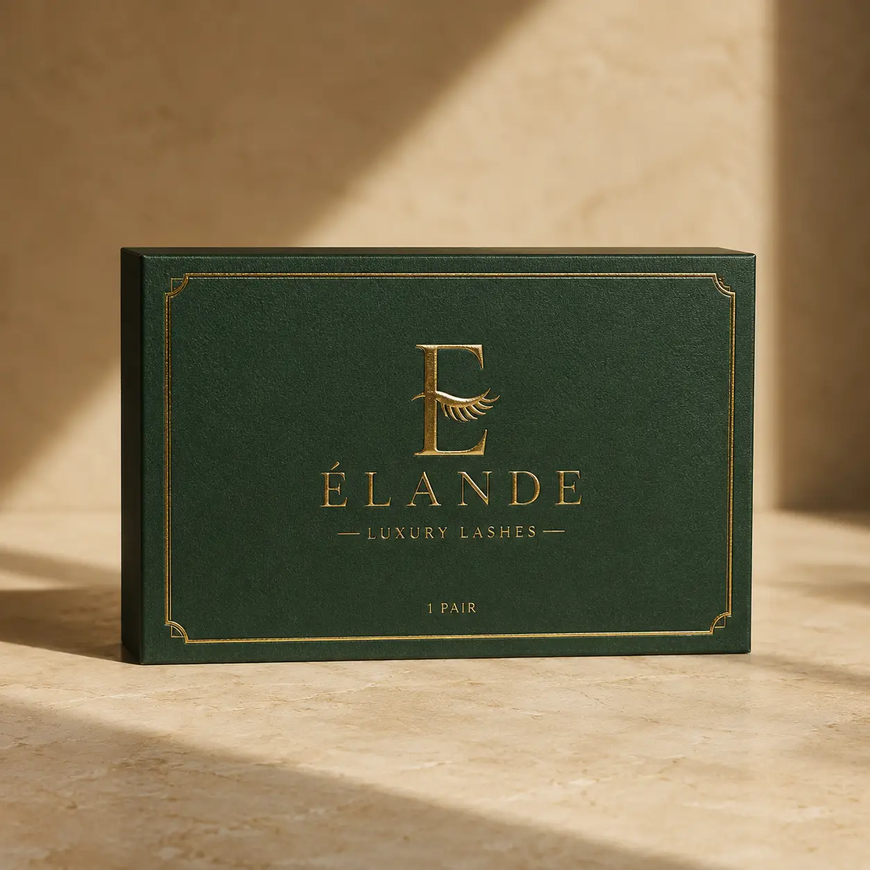 Élande Luxury Lashes emerald green gold foil packaging box on marble surface with warm natural lighting