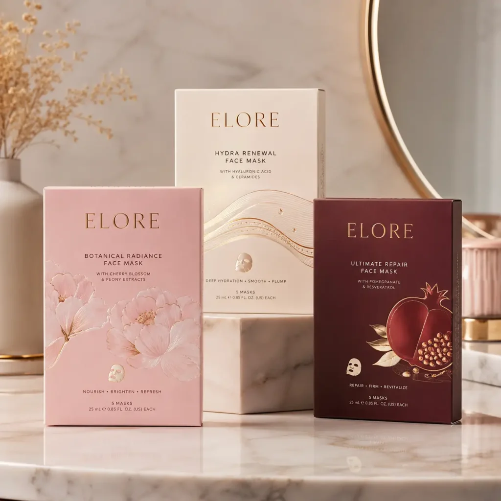 Three ELORE luxury face mask boxes in pink, cream, and burgundy displayed on marble surface with gold mirror backdrop