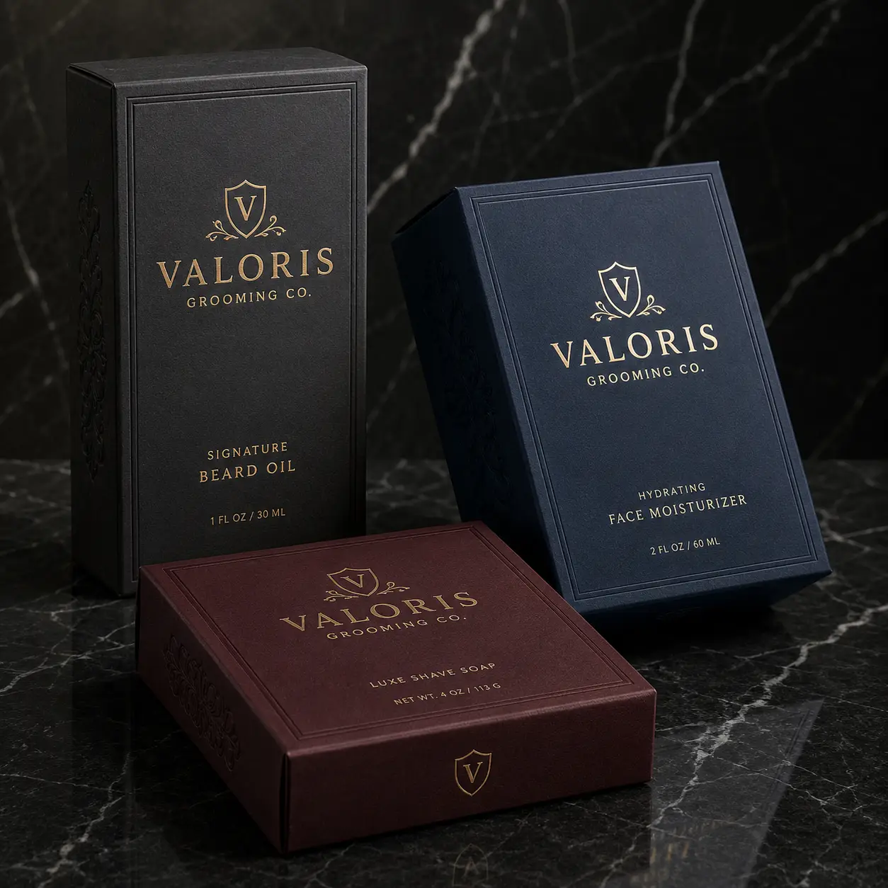 Valoris Grooming Co luxury packaging set featuring black beard oil box, navy moisturizer, and burgundy shave soap on dark marble