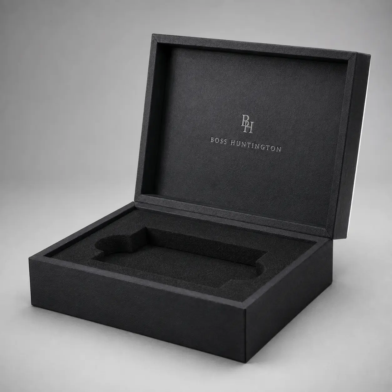Black luxury rigid gift box open showing foam insert with BH Boss Huntington logo, premium custom packaging by The Packaging Masters