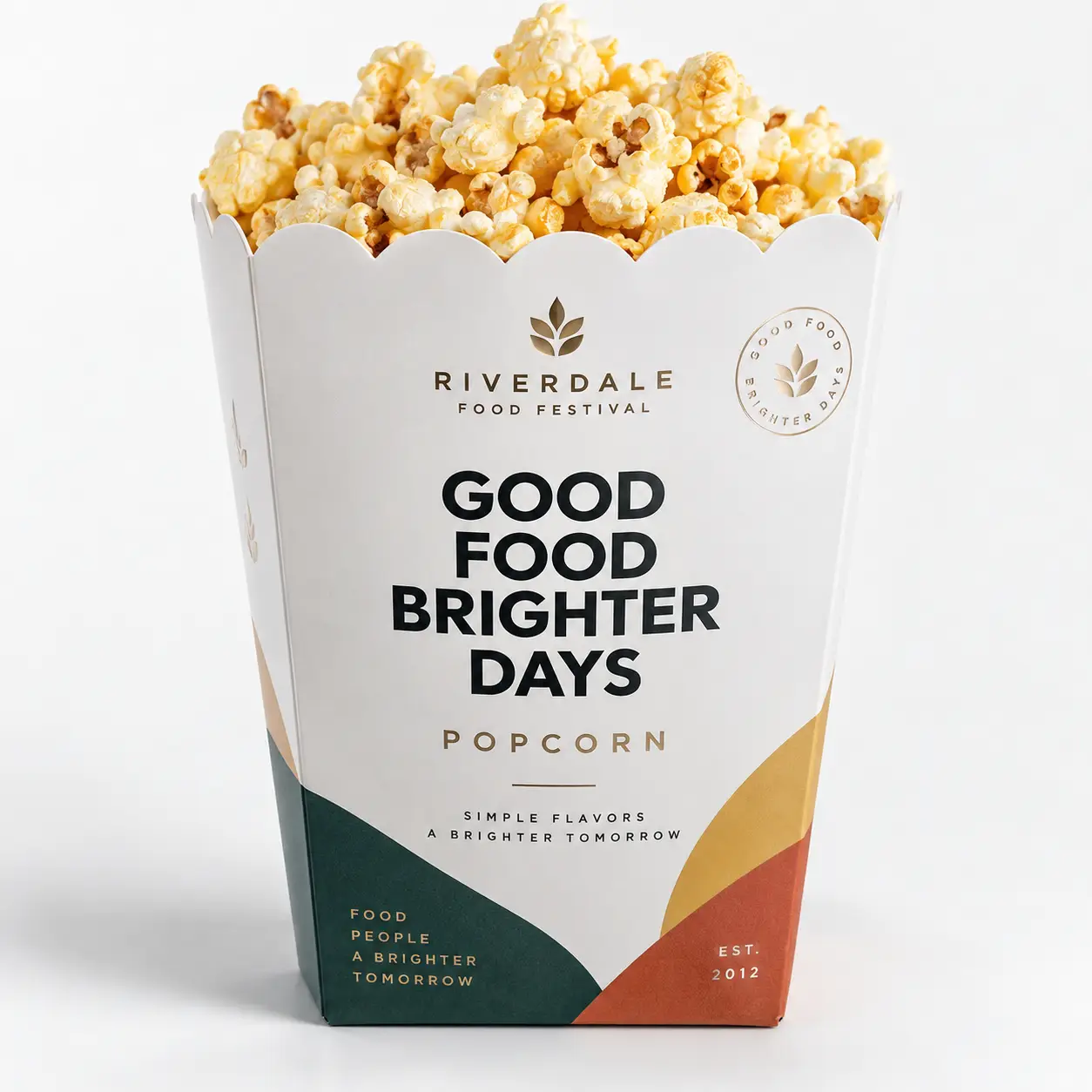 Riverdale Food Festival white popcorn box packaging with bold typography, green, gold, red accents, overflowing fresh popcorn, est. 2012