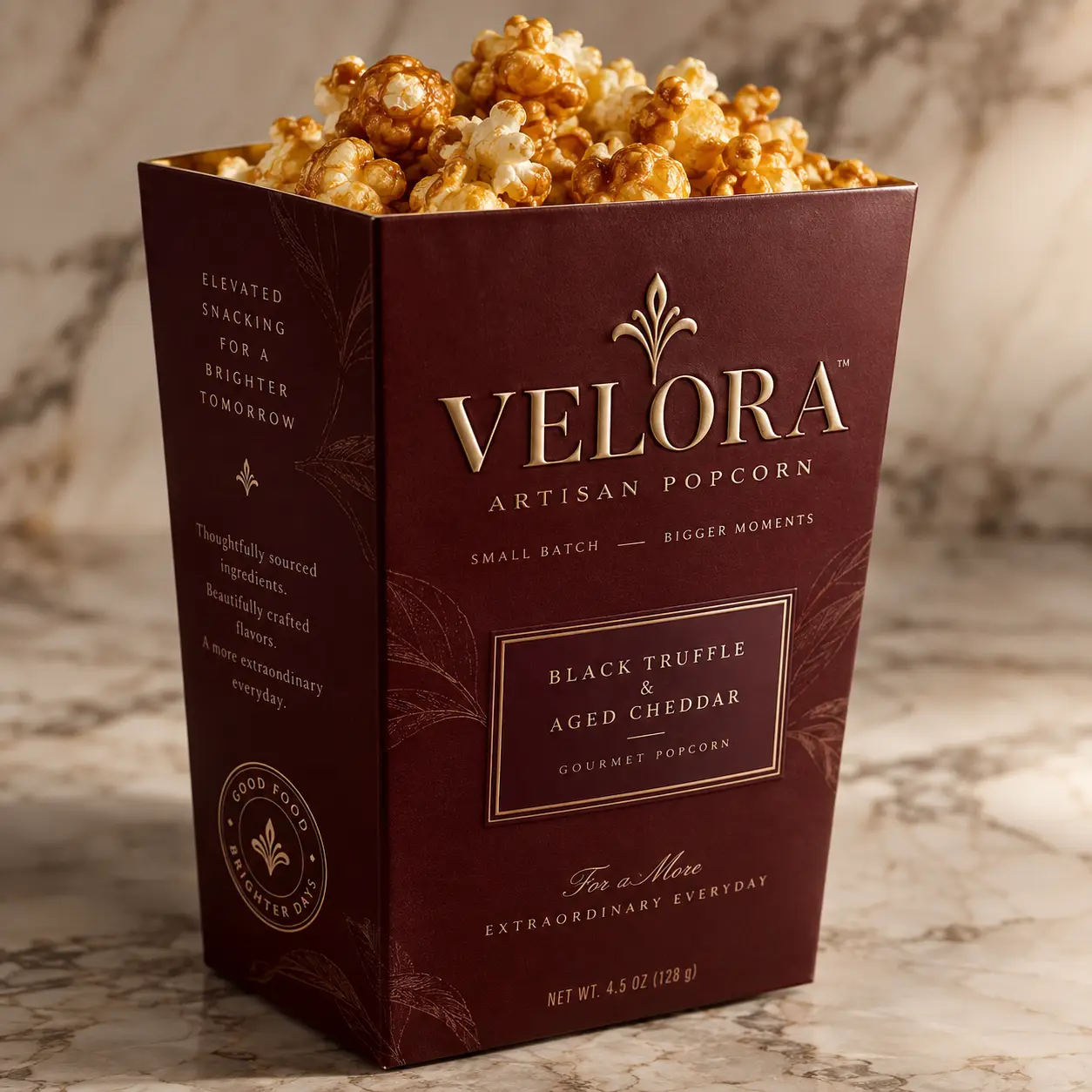 Velora Artisan Popcorn luxury packaging in deep burgundy and gold, Black Truffle Aged Cheddar gourmet box on marble surface