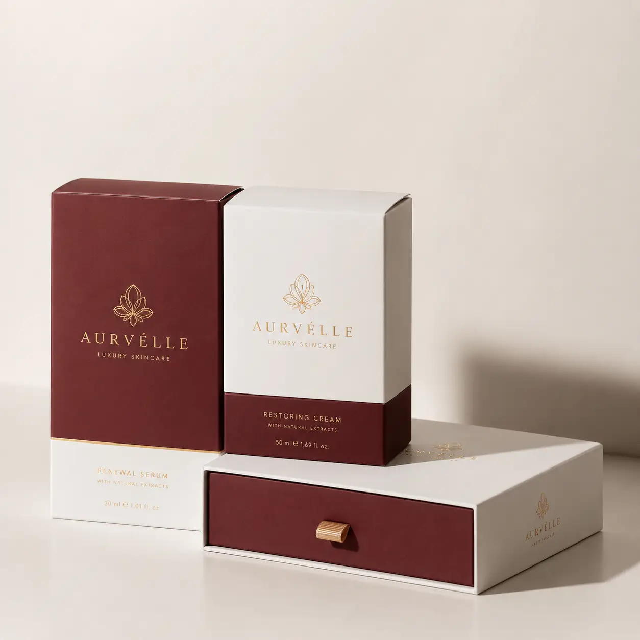 Aurvélle luxury skincare packaging set in white and burgundy with gold accents, featuring serum box, cream box, and drawer gift box