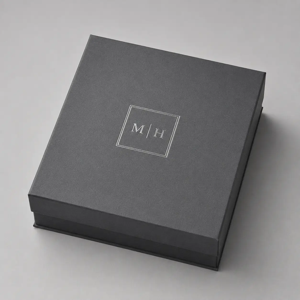 Dark gray luxury rigid gift box with silver M|H monogram logo, premium custom packaging by The Packaging Masters