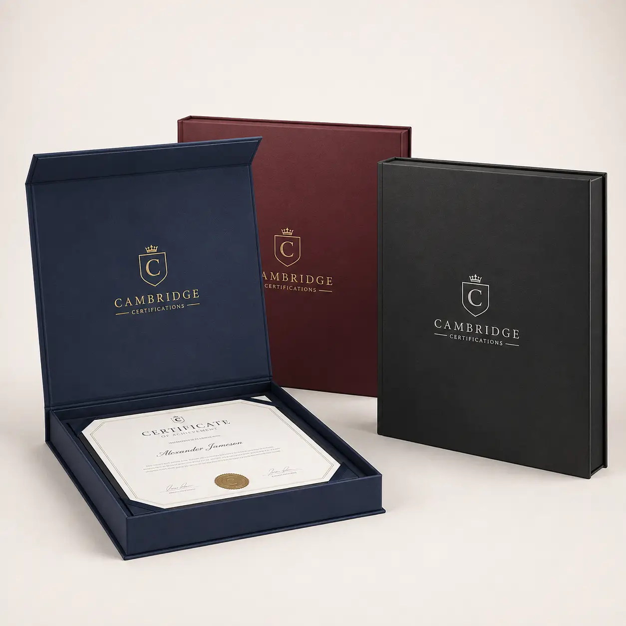 Navy, burgundy, black Cambridge Certifications luxury certificate presentation boxes with gold foil logo, open box displaying achievement certificate