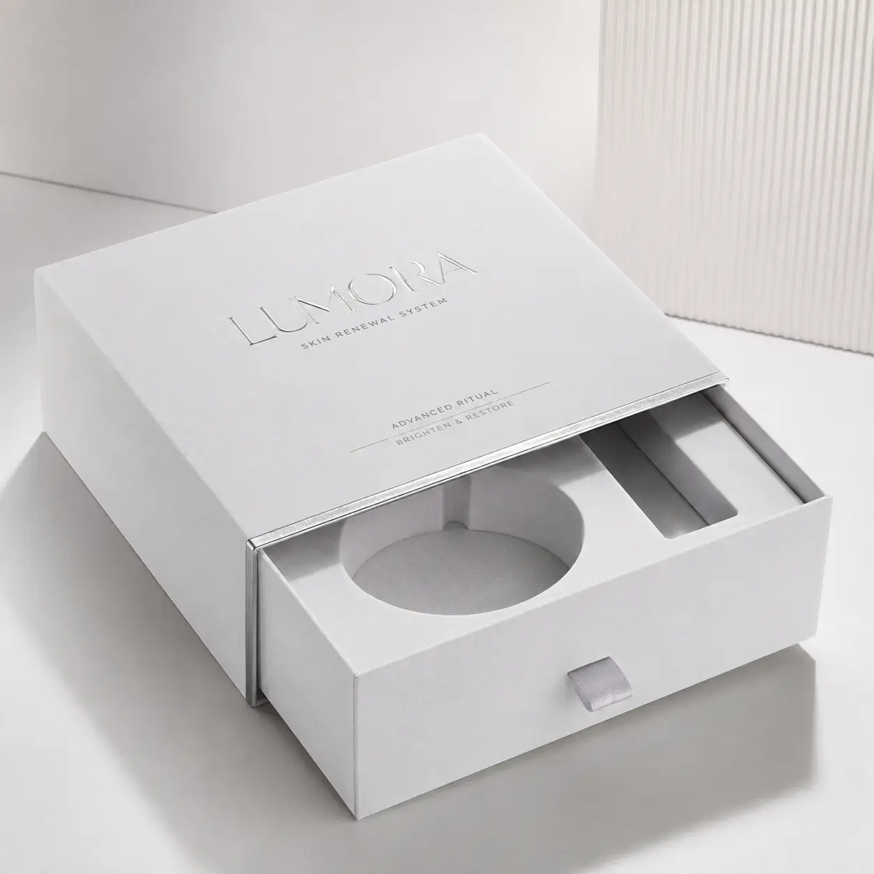 Lumora Skin Renewal System luxury white drawer gift box with silver foil embossing and molded insert tray premium cosmetic packaging