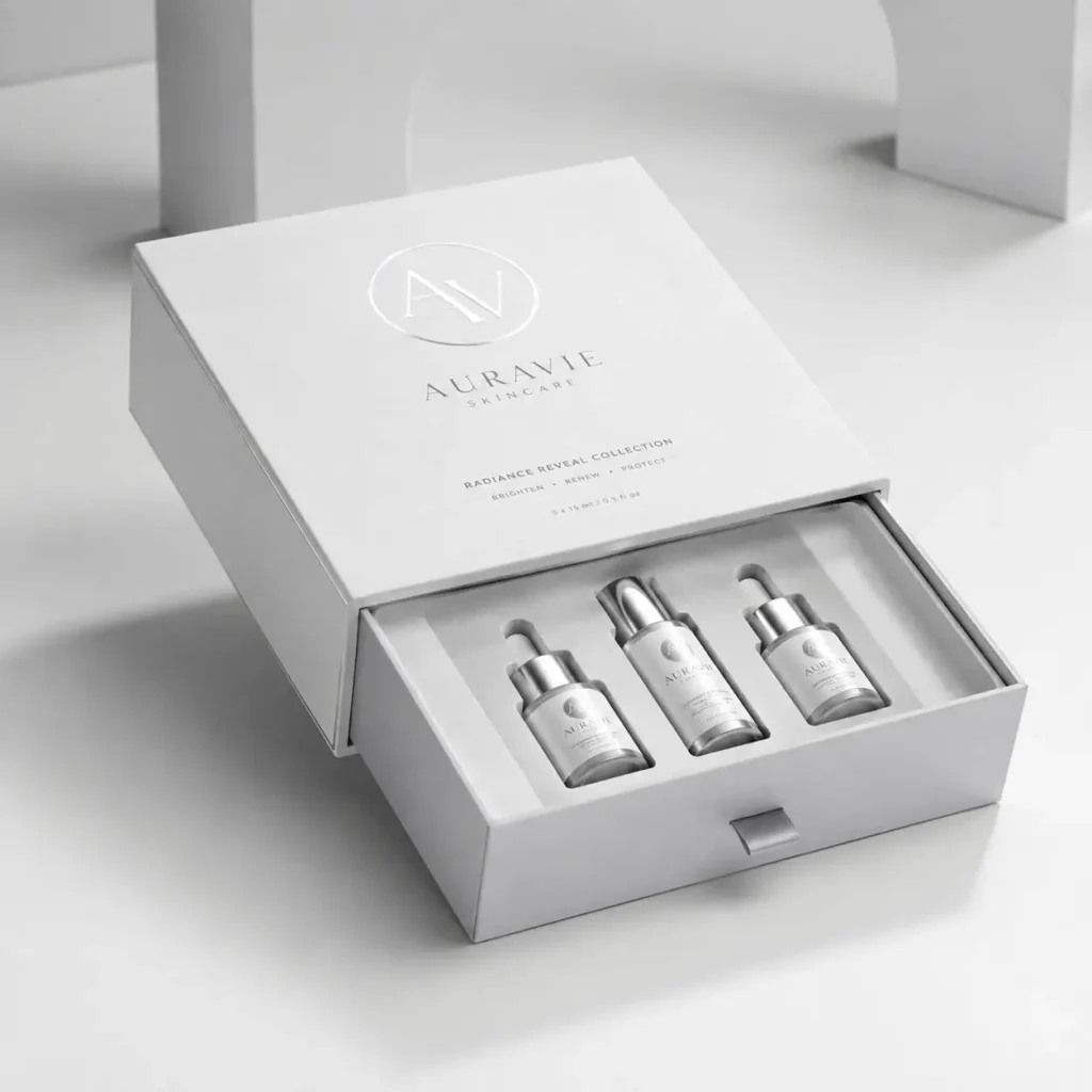 Auravie Skincare Radiance Reveal Collection luxury white gift box with three serum dropper bottles, elegant silver packaging design