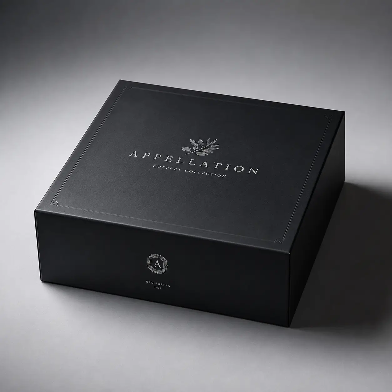 Luxury black gift box with silver Appellation Coffret Collection logo and olive branch, premium packaging design California USA