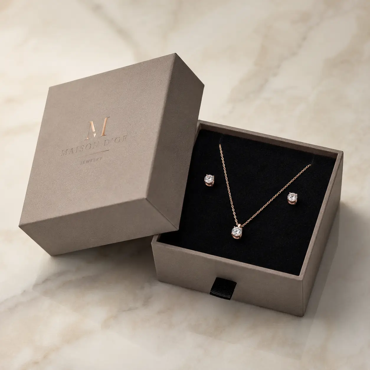 Maison D'Or luxury jewelry gift box in taupe with rose gold necklace and crystal stud earrings on black velvet insert