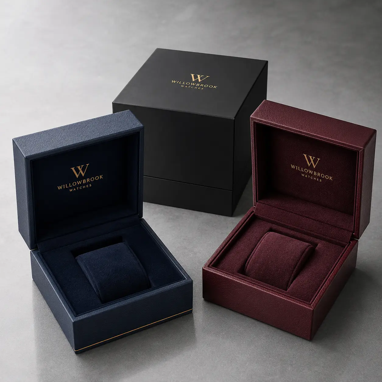 Three luxury watch boxes by Willowbrook Watches in navy blue, burgundy, and black with gold branding on gray background
