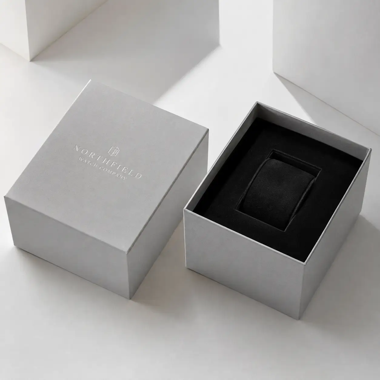 Silver Northfield Watch Company luxury gift box with black velvet cushion insert, lid removed, minimalist white background