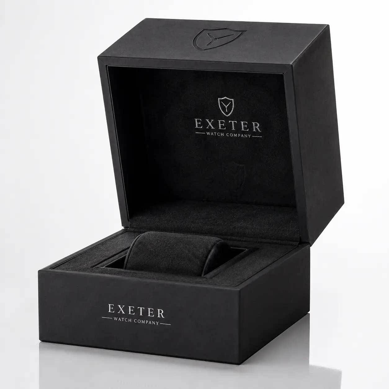 Black luxury watch box by Exeter Watch Company, open displaying velvet cushion interior, silver logo embossed, elegant packaging