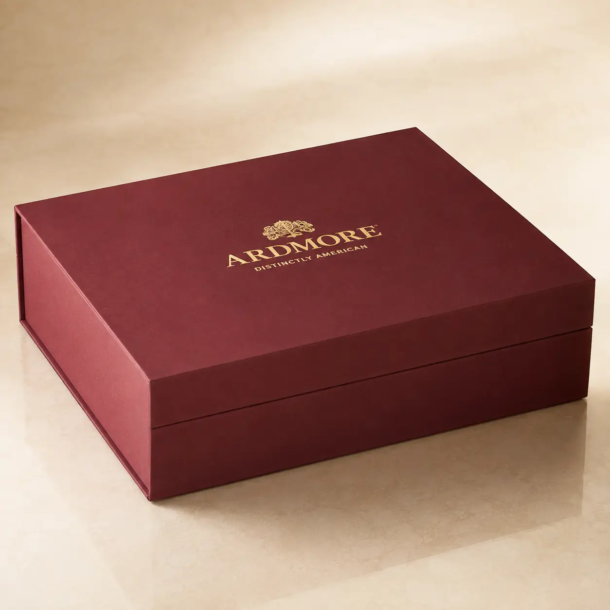 Ardmore Distinctly American luxury rigid gift box in deep burgundy with gold foil logo on cream surface