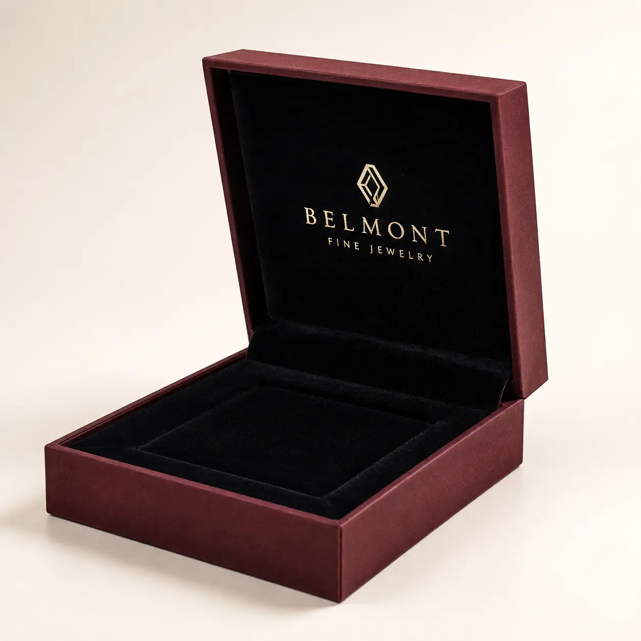 Luxury burgundy jewelry box open displaying black velvet interior with gold Belmont Fine Jewelry logo branding