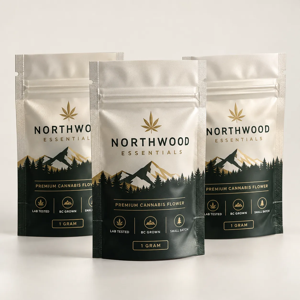 Three silver Northwood Essentials 1-gram premium cannabis flower mylar pouches with gold leaf logo and mountain forest design
