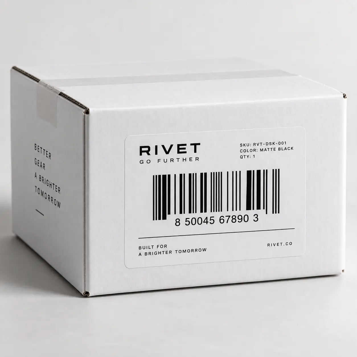 White Rivet branded corrugated shipping box with barcode label, matte black text, minimalist product packaging design