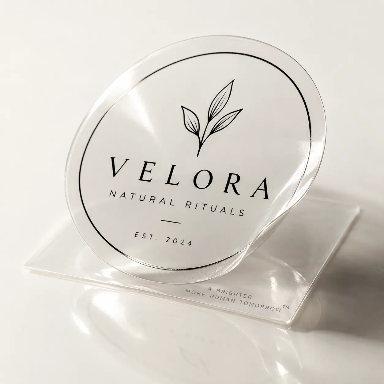 Velora Natural Rituals clear round sticker label EST 2024 with botanical leaf design on transparent packaging sheet