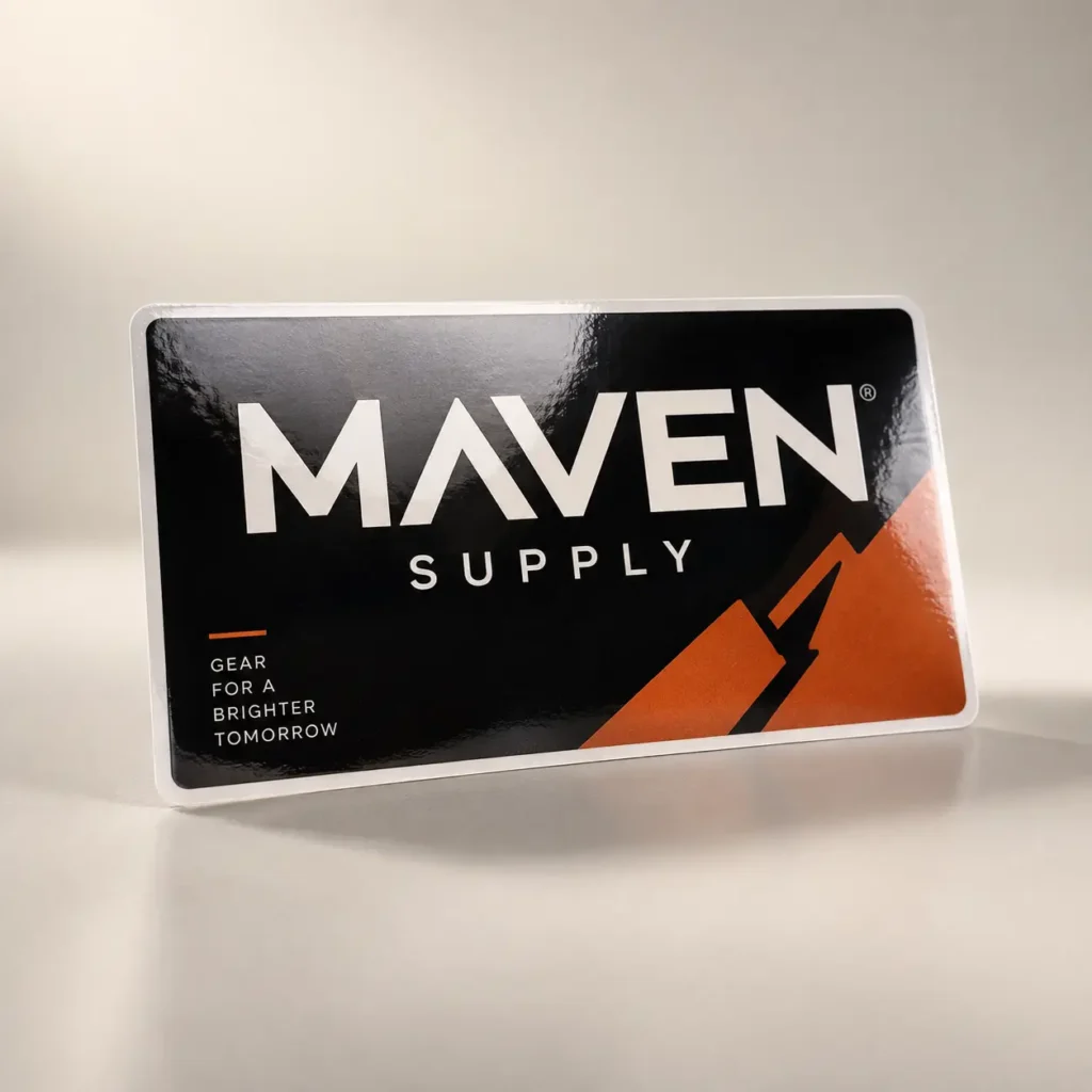 Maven Supply branded sticker with bold white text on black background, orange mountain graphic, reads Gear For A Brighter Tomorrow