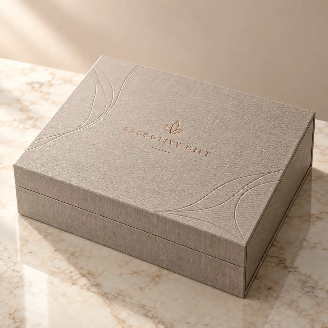 Luxury linen-textured executive gift box with gold embossed logo on marble surface, elegant corporate packaging by The Packaging Masters
