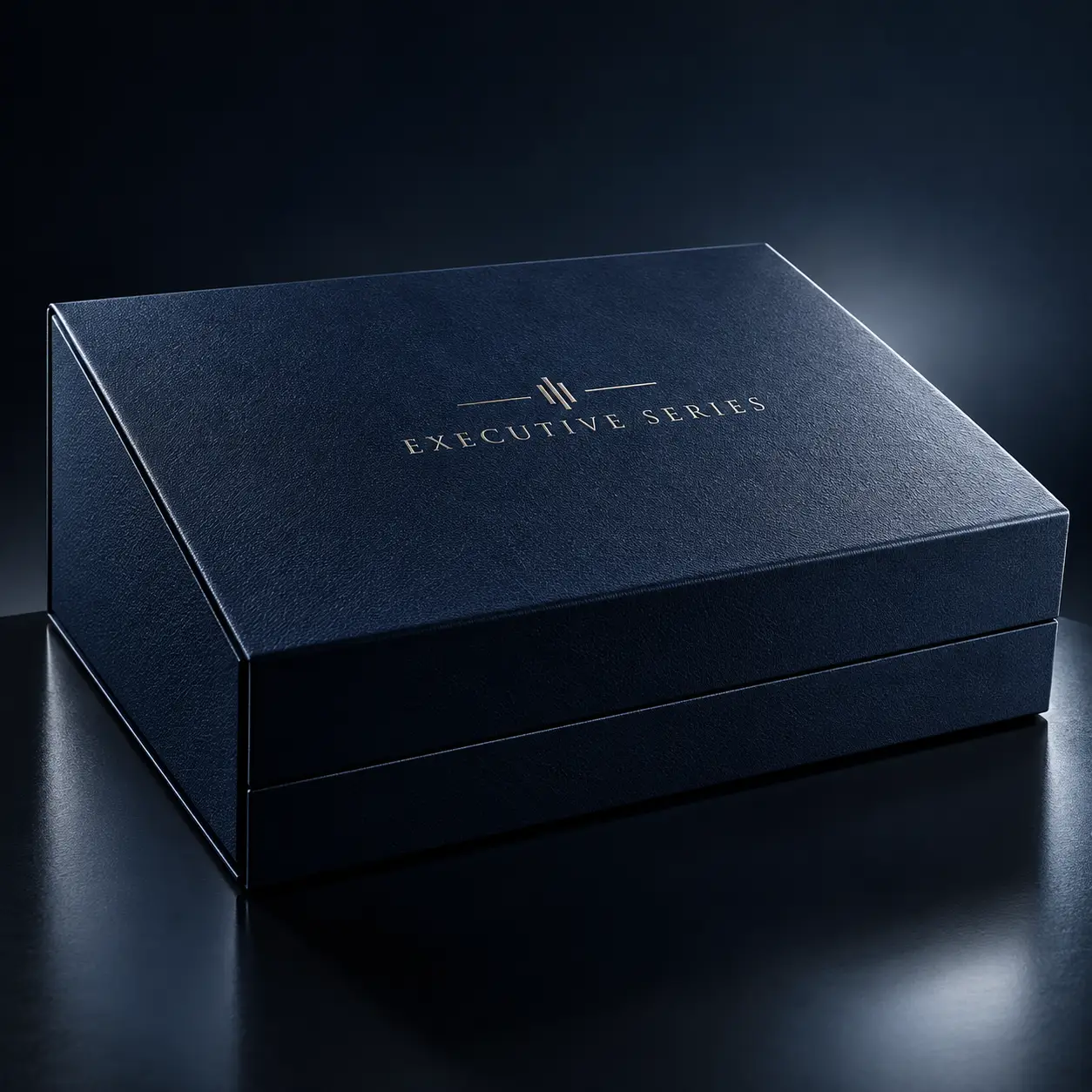 Navy blue luxury gift box with gold Executive Series logo on dark reflective surface, premium rigid packaging by The Packaging Masters