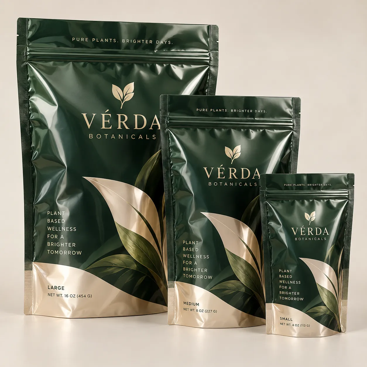 Three dark green gold Vérda Botanicals plant-based wellness powder pouches in small medium large sizes on neutral background